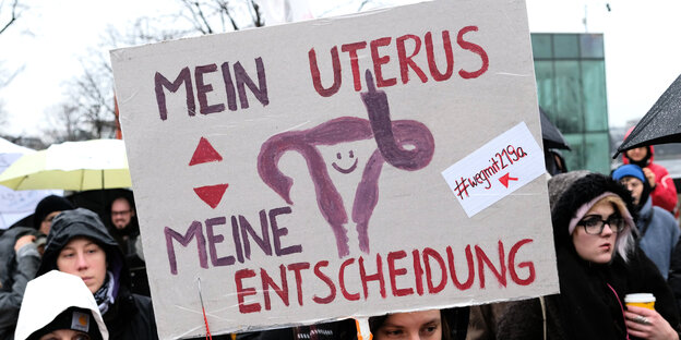 Eine Teilnehmerin einer Demonstration gegen die Paragrafen 218 und 219a, die Schwangerschaftsabbrüche und das Werbeverbot dafür regeln, hält ein Schild mit der Aufschrift "Mein Uterus, meine Entscheidung" hoch