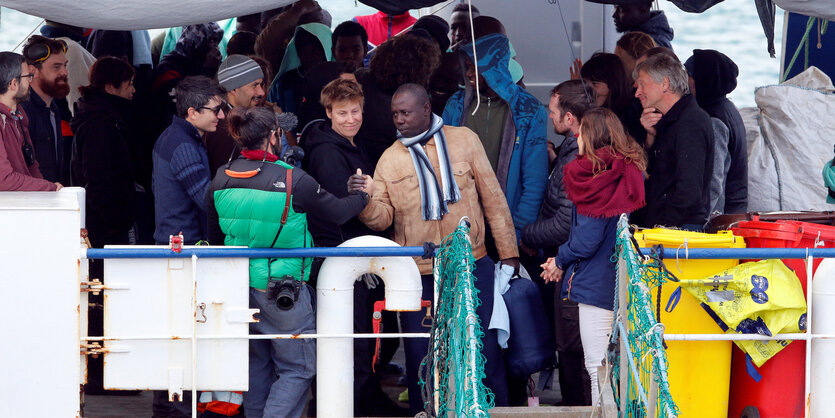 Menschen klettern vom Schiff an Land