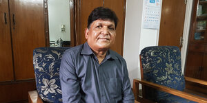 Chandra Bhan Prasad sitz auf einem Stuhl in seinem Büro.