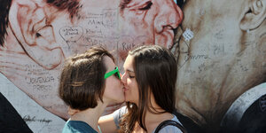Zwei junge Frauen küssen sich.