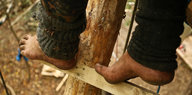 Füße eines Aktivisten stehen auf einer Sprosse im Hambacher Forst