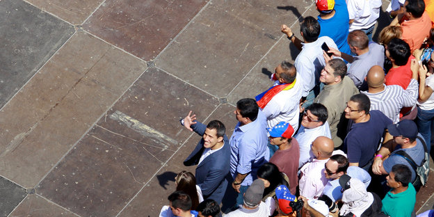Juan Gaudio winkt bei einer Demo gegen Venezuelas Präsident Nicolás Maduro