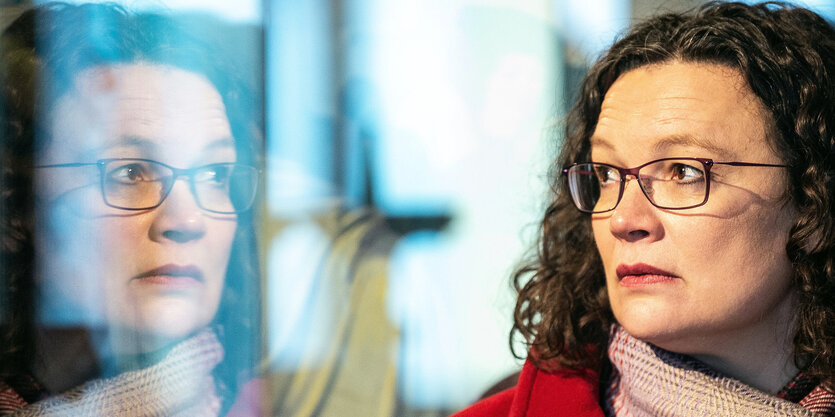 Andrea Nahles schaut durch ein Fenster und sieht ihr Spiegelbild