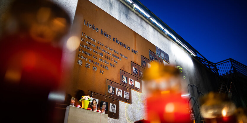 Blick auf eine Wand, mit Treppe davor, mit Blumen und Bildern