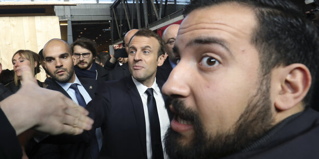 Emmanuel Macron (M), Präsident von Frankreich, besucht mit seinem damaligen Leibwächter Alexandre Benalla (r) die Landwirtschaftsmesse.