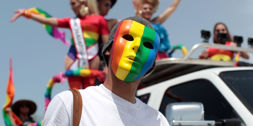 Menschen mit Regenbogensymbolen tanzen