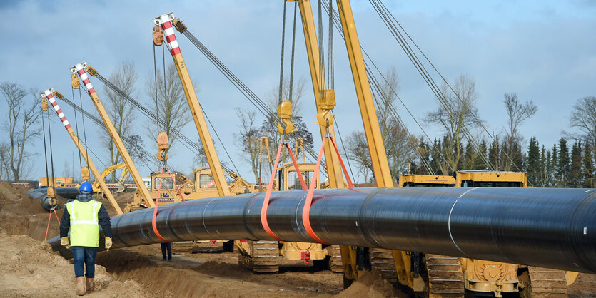 Ein Pipelinestück wird ins Erdreich gelegt