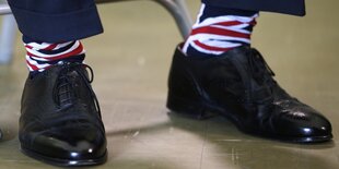 Zwei Schuhe, daraus sichtbar Socken im Union-Jack-Design