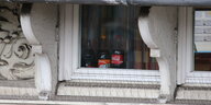 Drei Flaschen stehen hinter einem Fenster. In der linken ist eine Kamera zu erkennen