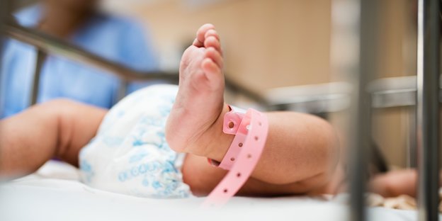 Der Fuß und das Bein eines Neugeborenen