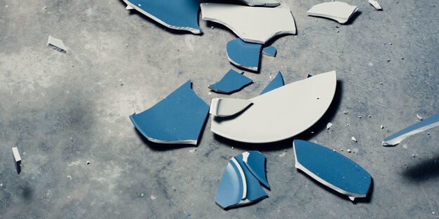 zerbrochene blaue Keramikteller auf dem Boden