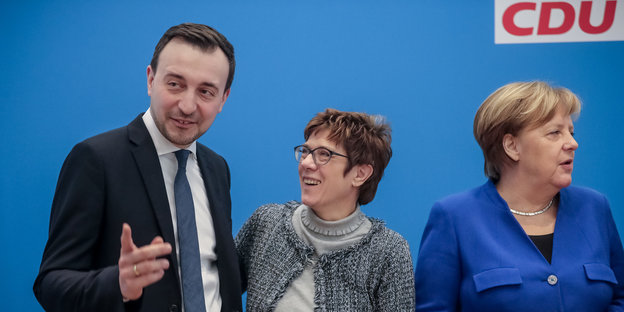 Annegret Kramp-Karrenbauer steht zwischen Paul Ziemiak und Angela Merkel