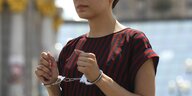 Eine Frau trägt Handschellen, sie protestiert