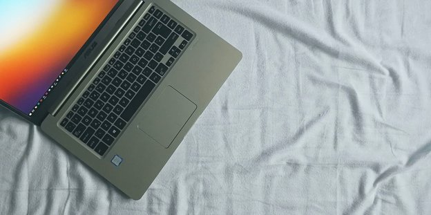 Ein Laptop steht auf dem Bett