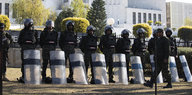 eine Reihe schwer ausgerüsteter Polizisten mit Schutzschildern