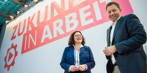 Andrea Nahles steht neben Lars Klingbeil, dahinter steht "Zukunft in Arbeit" auf der Wand