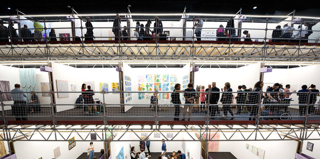 Menschen stehen in einer Halle auf Galerien