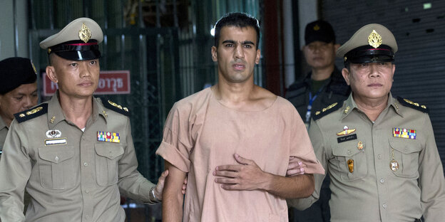 Hakim Al-Araibi verlässt in Begleitung von zwei Polizisten das Strafgericht.