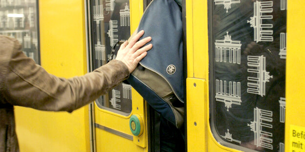 Jemand klemmt mit dem Rucksack in einer U-Bahn-Tür