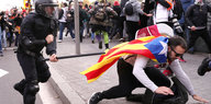 In Barcelona verfolgt ein Polizist einen katalanischen Demonstranten
