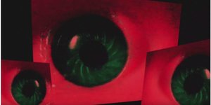 Drei grüne Augen auf rotem Hintergrund