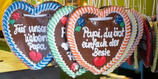 Lebkuchenherzen hängen an Schnüren. Auf einem steht: „Papi, du bist einfach der Beste“