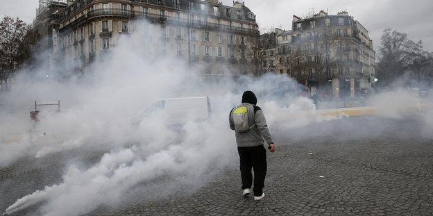 Ein Demonstrant steht in einer Tränengaswolke