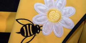 Ein Teilnehmer der Abschlussveranstaltung des Volksbegehrens Artenvielfalt hat eine Biene auf seinem Anzug