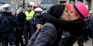 Zwei Menschen küssen sich vor einer Demo
