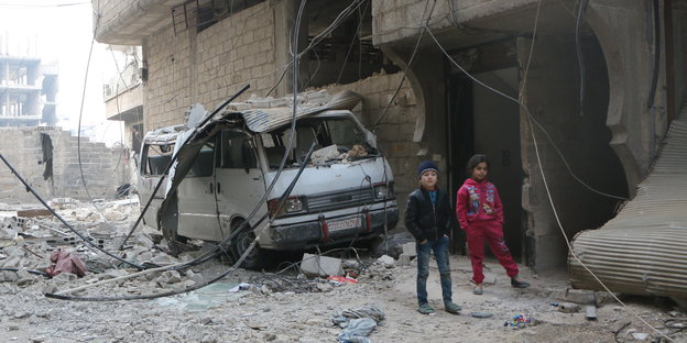 Zwei Kinder im syrischen Ost-Ghuta vor völlig zerstörten Häusern