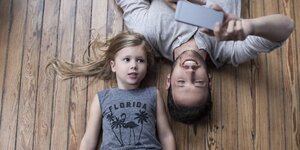 Mädchen und Vater mit Smartphone