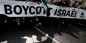 Demonstrierende mit Transparent, darauf "Boycott Israel"