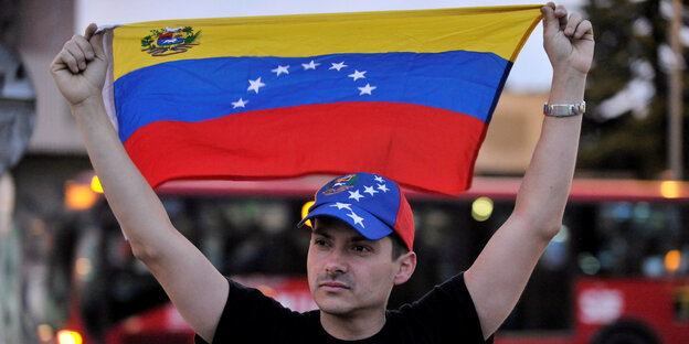 Ein Venezolaner protestiert mit einer Flagge in Bogotá für seine getöteten Landsleute