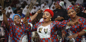Drei Frauen tanzen bei einer Wahlkampfveranstaltung des Präsidenten von Nigeria Buhari