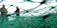 Zwei Fischer halten ein grünes Netz in ihren Händen.