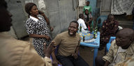 Nigerianer diskutieren beim Biertrinken