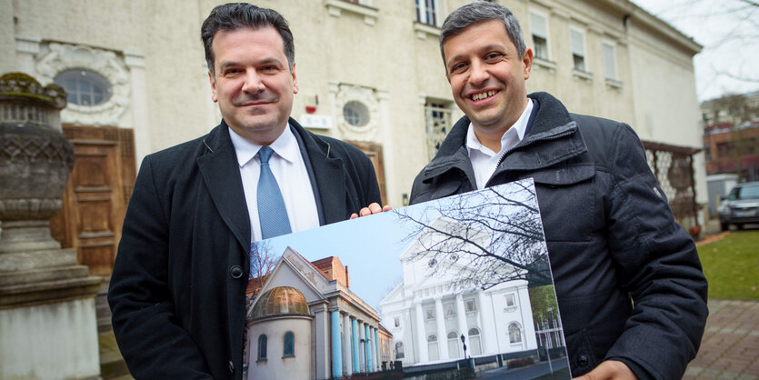 Gideon Joffe (l-r), Vorsitzender der Jüdischen Gemeinde zu Berlin, und Raed Saleh, Vorsitzender der SPD-Fraktion im Abgeordnetenhaus in Berlin, zeigen auf dem Hof der Synagoge am Fraenkelufer im Bezirk Kreuzberg in Berlin eine Bildtafel mit einem Entwurf