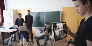 Ein Schüler hält ein Tablet in der Hand