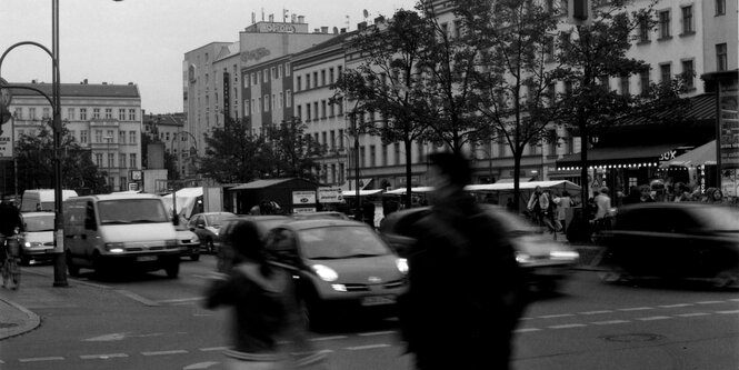 Eine Straßenecke mit Ampel und viel Verkehr und Fußgängern