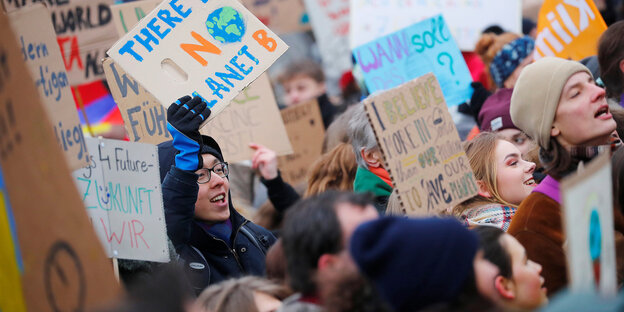 Schülerinnen und Schüler protestieren mit Plakaten für den Klimaschutz