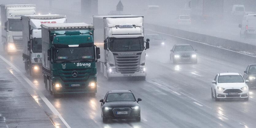 Mehrere Fahrzeuge, darunter auch Lkw, auf einer Autobahn bei Regen