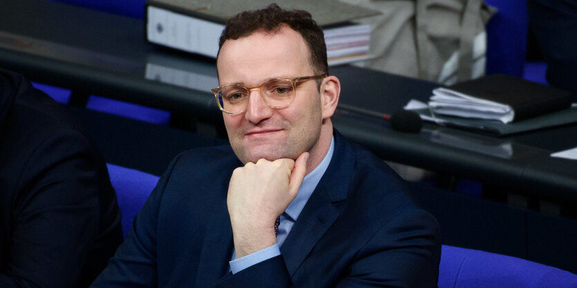 Jens Spahn sitzt zufrieden im Bundestag