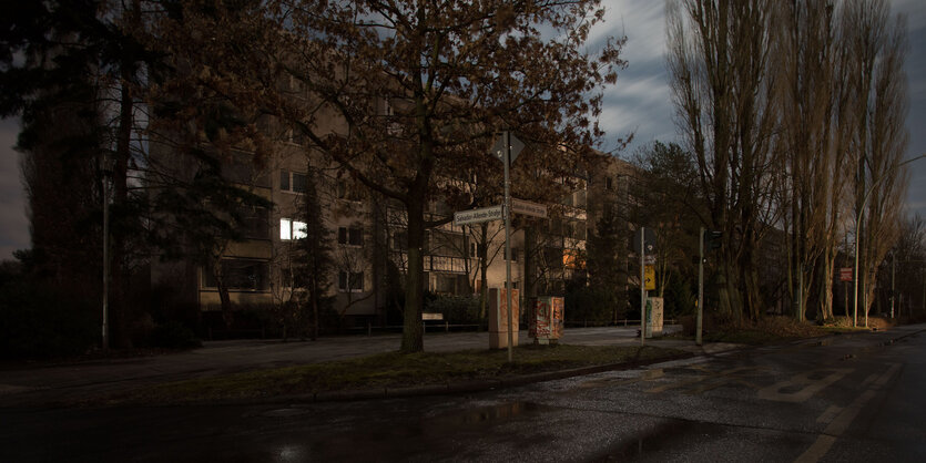 In einem von der Straße fotografierten Mehrfamilienhaus brennt nur in einem Zimmer Licht