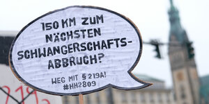 Ein Demo-Schild mit der Aufschrift "150km zum nächsten Schwangerschaftsabbruch? Weg mit §219".