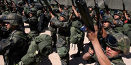 mexikanische uniformierte soldaten bereiten sich für einen einsatz vor und halten ihre sturmgewehre hoch