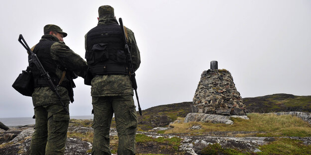 Zwei Grenzwächter stehen an der norwegisch-russichen Grenze
