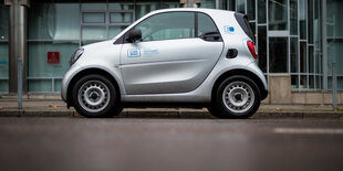 Ein silbernes Auto von Car2Go steht auf dem Asphalt.