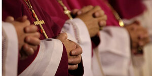 Bischöfe falten ihre Hände zum Gebet