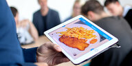 Berliner Schüler schaut sich auf einem Tablet ein Schnitzel-Pommes-Gericht an