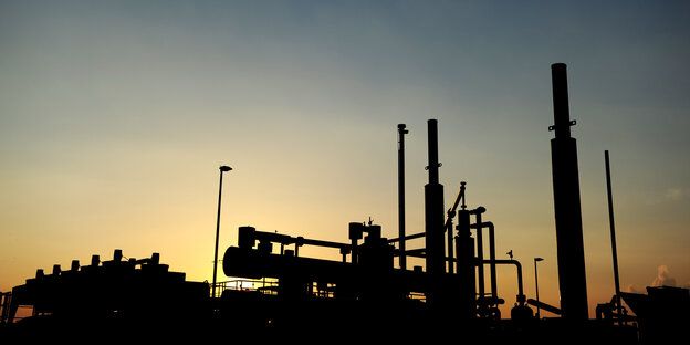 Silhouette einer Gasförderungsanlage vor Abendhimmel.